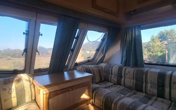 A very neat English caravan for 4 with all amenities and view of the horses