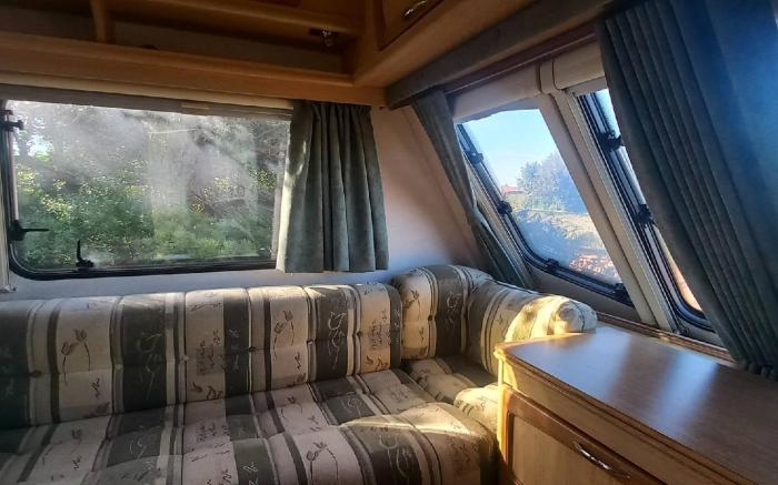 A very neat English caravan for 4 with all amenities and view of the horses