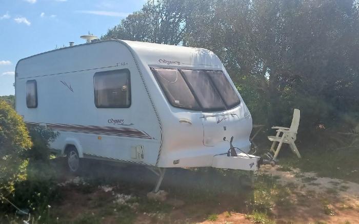 A very neat English caravan for 4 with all amenities and view of the horses