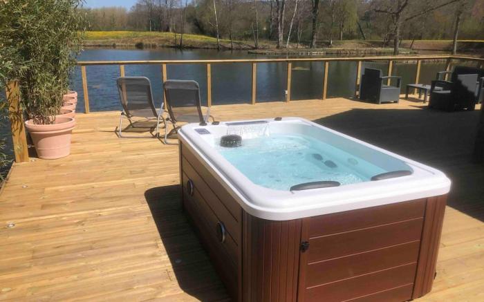 Chalet with a hot tub and terrace above the water